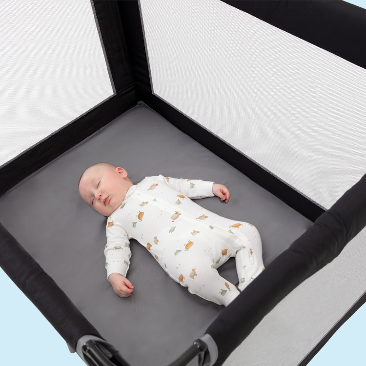 Baby sleeping in Graco Compact travel cot.