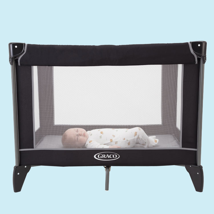 Baby sleeping seen through the mesh of Graco Compact travel cot. 