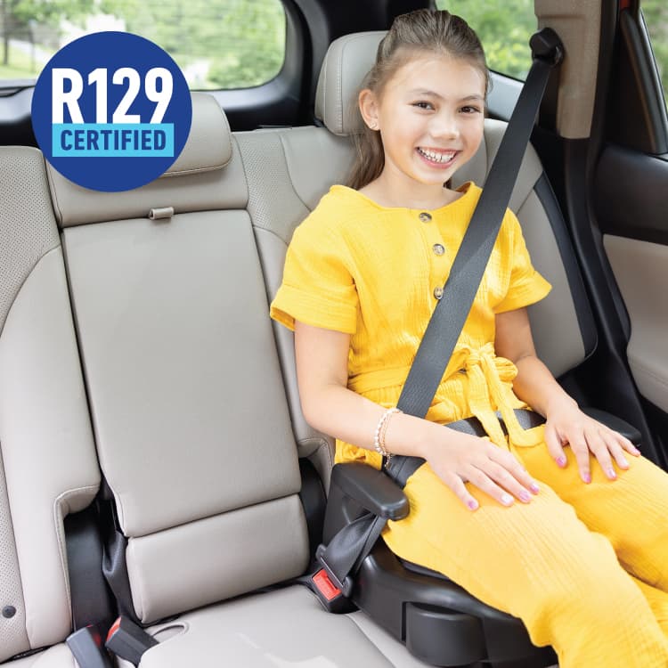 Young girl smiling and sitting in Graco Booster Basic R129 highback booster with R129 logo. 