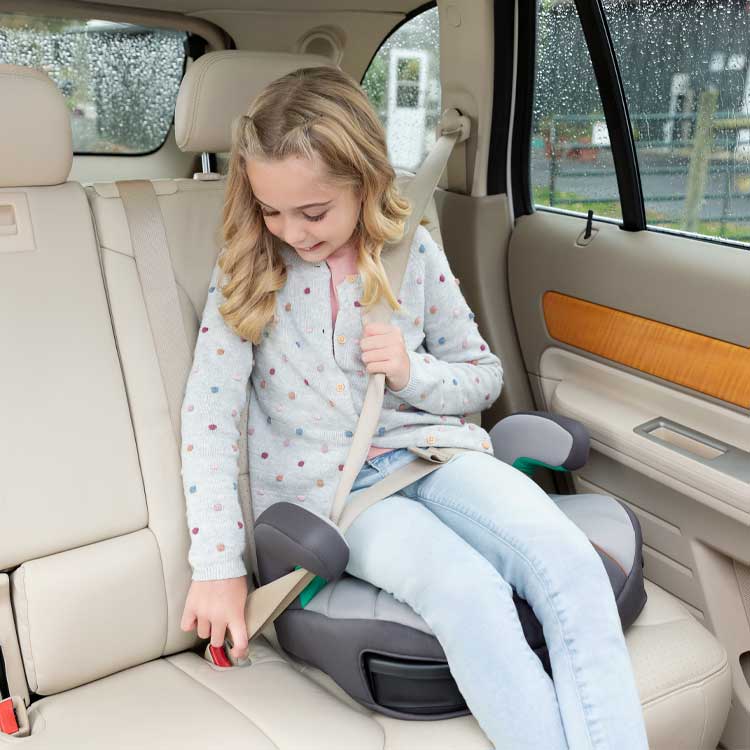 Petite fille assise sur le Graco EverSure Lite et bouclant son siège-auto