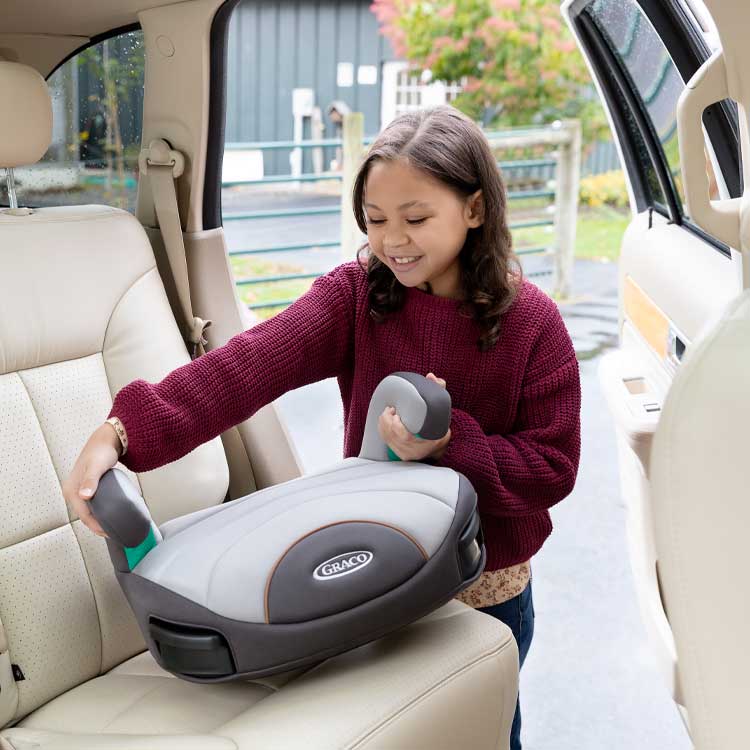 Junges Mädchen platziert den Kindersitz Graco EverSure™ Lite im Auto
