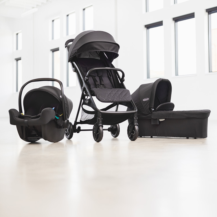 Passeggino Myavo, navicella Myavo e seggiolino auto SnugLite i-Size R129 allineati sul pavimento dello studio
