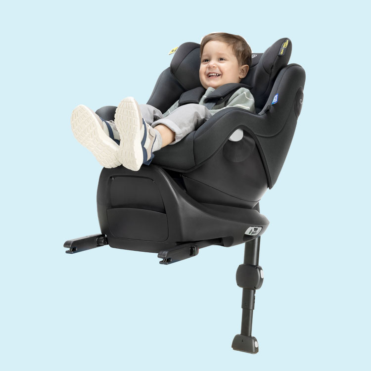 Little boy smiling and buckled in SnugGo i-Size R129 in rearward facing mode and connected to the SnugTurn i-Size R129 rotating ISOFIX base