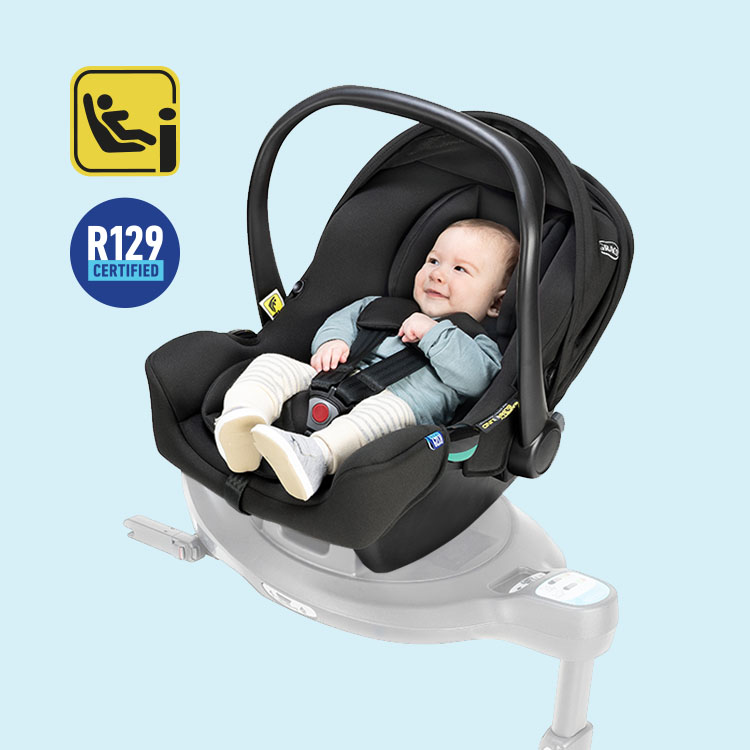Baby sitting in Graco SnugLite i-Size R129 infant car seat with i-Size and R129 logos