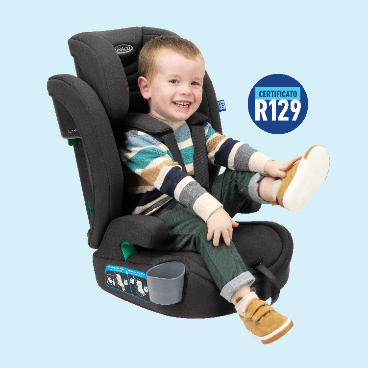 Bambino allacciato con la cintura su Graco Eldura R129 mentre ride e scalcia con il logo certificato R129
