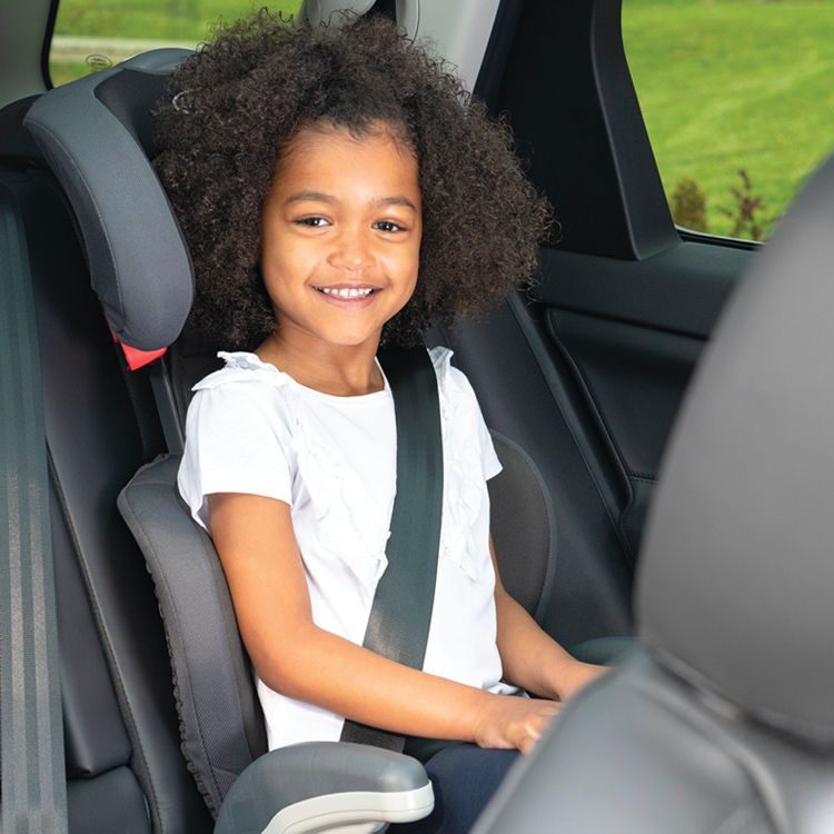 Petite fille assise dans le siège-auto Graco Junior Maxi avec l'appui-tête ajusté à sa taille