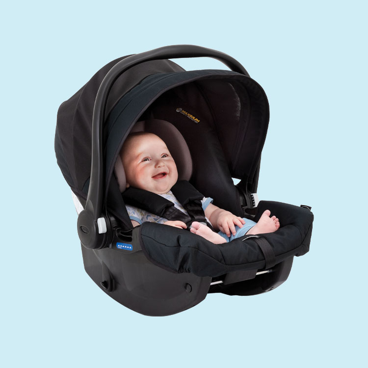 Bebé feliz en la silla de coche Graco SnugEssentials i-Size sobre fondo azul.

