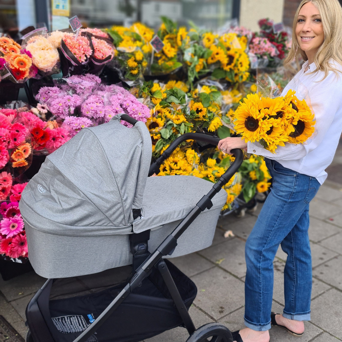 Mum and baby on a walk in Graco Transform in city.