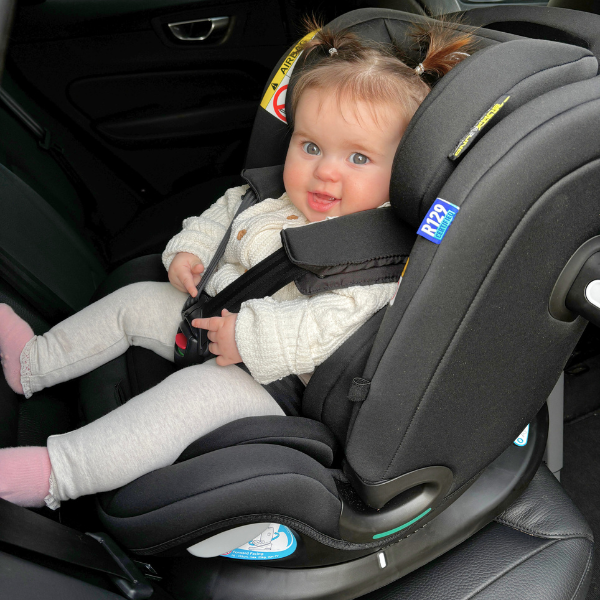 Baby standing in Graco FoldLite in nursery.