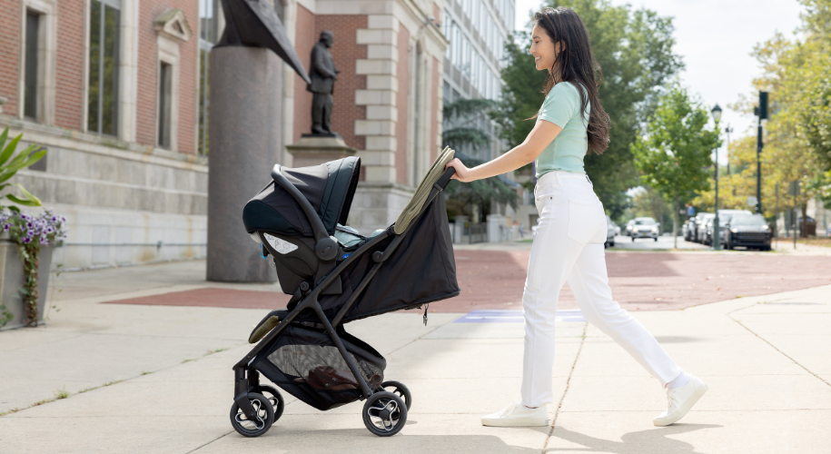 Mum pushing Graco Myavo Travel System with SnugEssentials i-Size R129 attached.